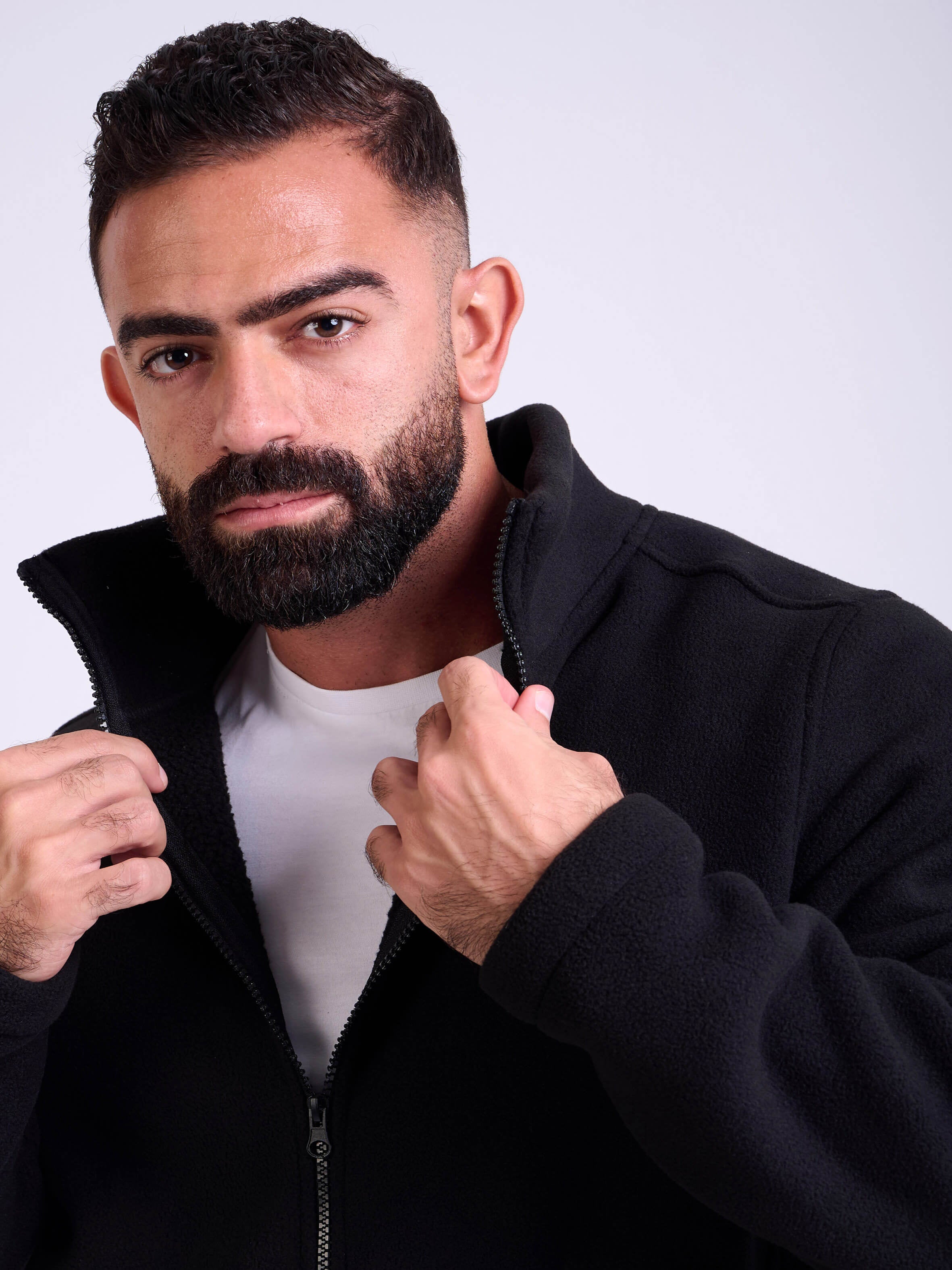 Man wearing a black fleece jacket by KAF on a white background. Made in Egypt
