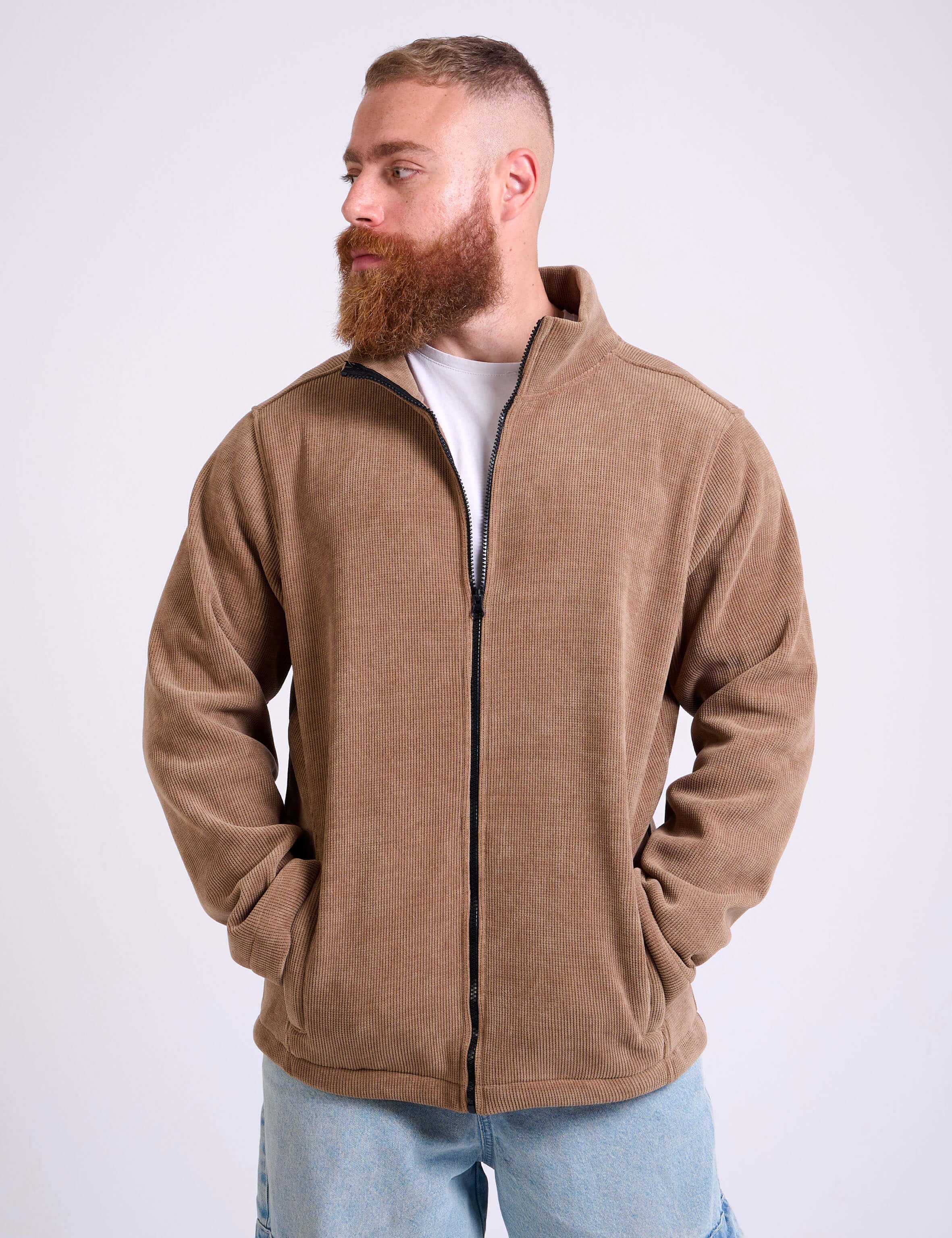 Man wearing a camel beige corduroy jacket on a white background