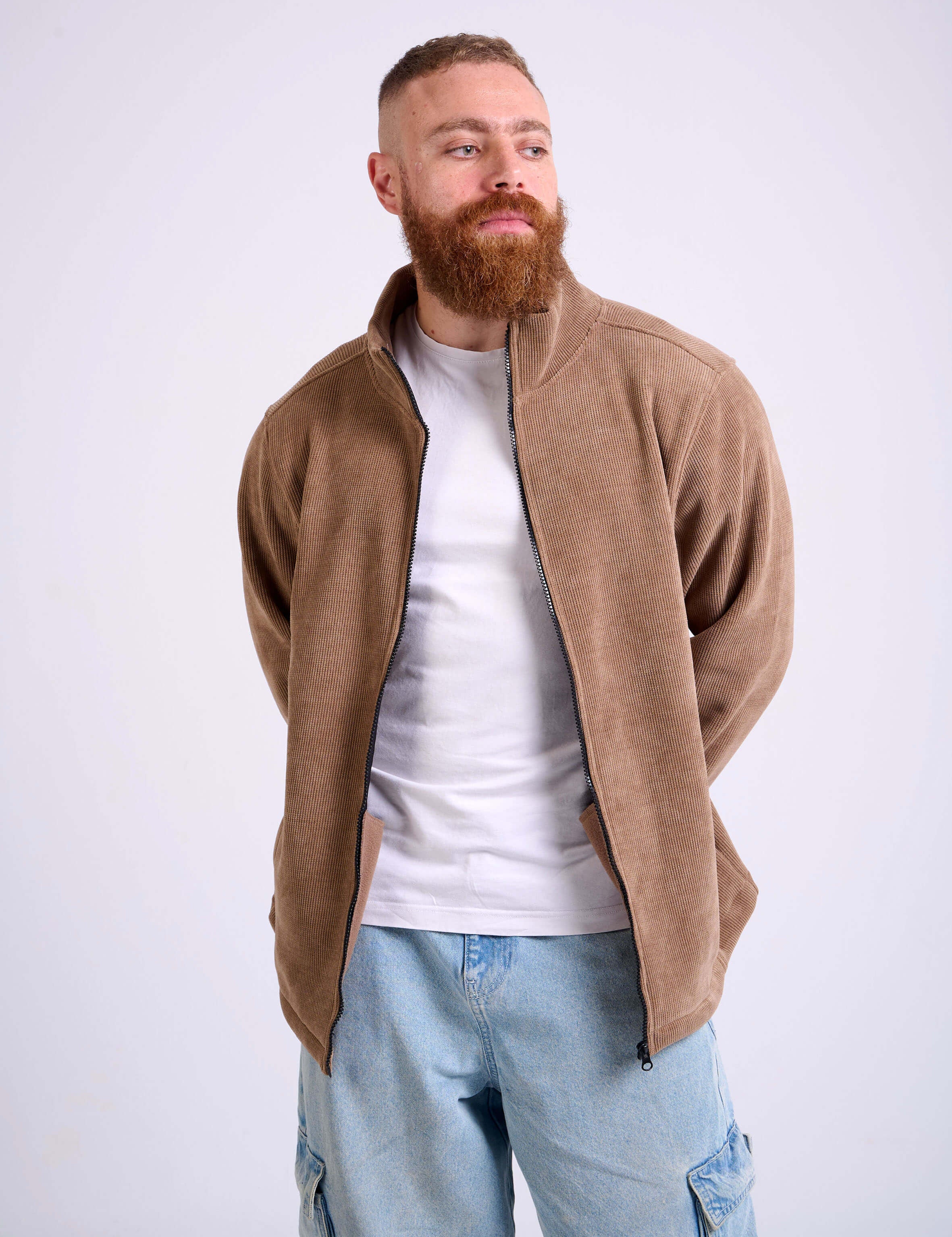 Man wearing a camel beige corduroy jacket on a white background