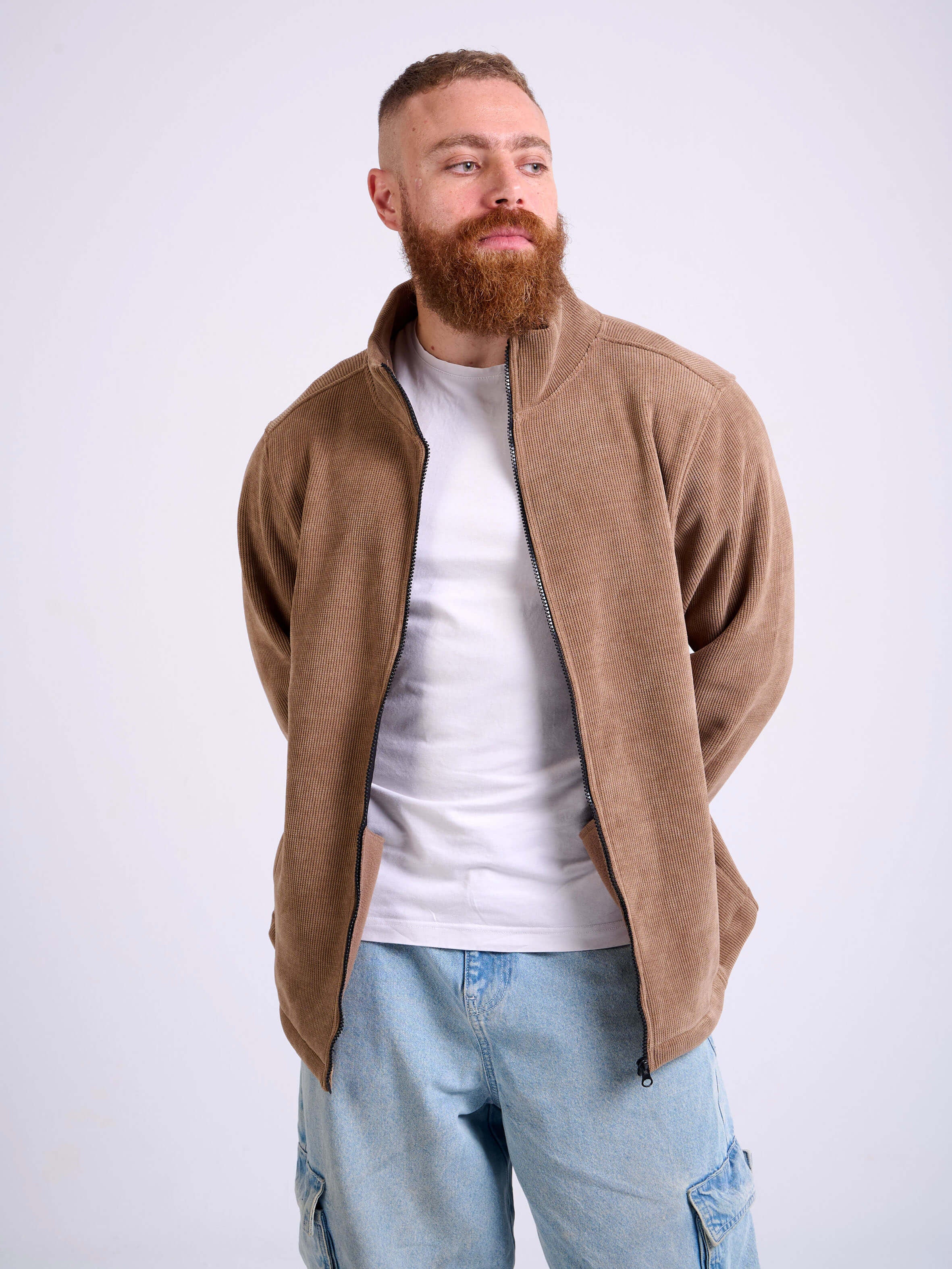 Man wearing a camel beige corduroy jacket on a white background