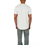 A male model wearing a white raw-edged cotton crew neck t-shirt with short sleeves and a rounded hem.
