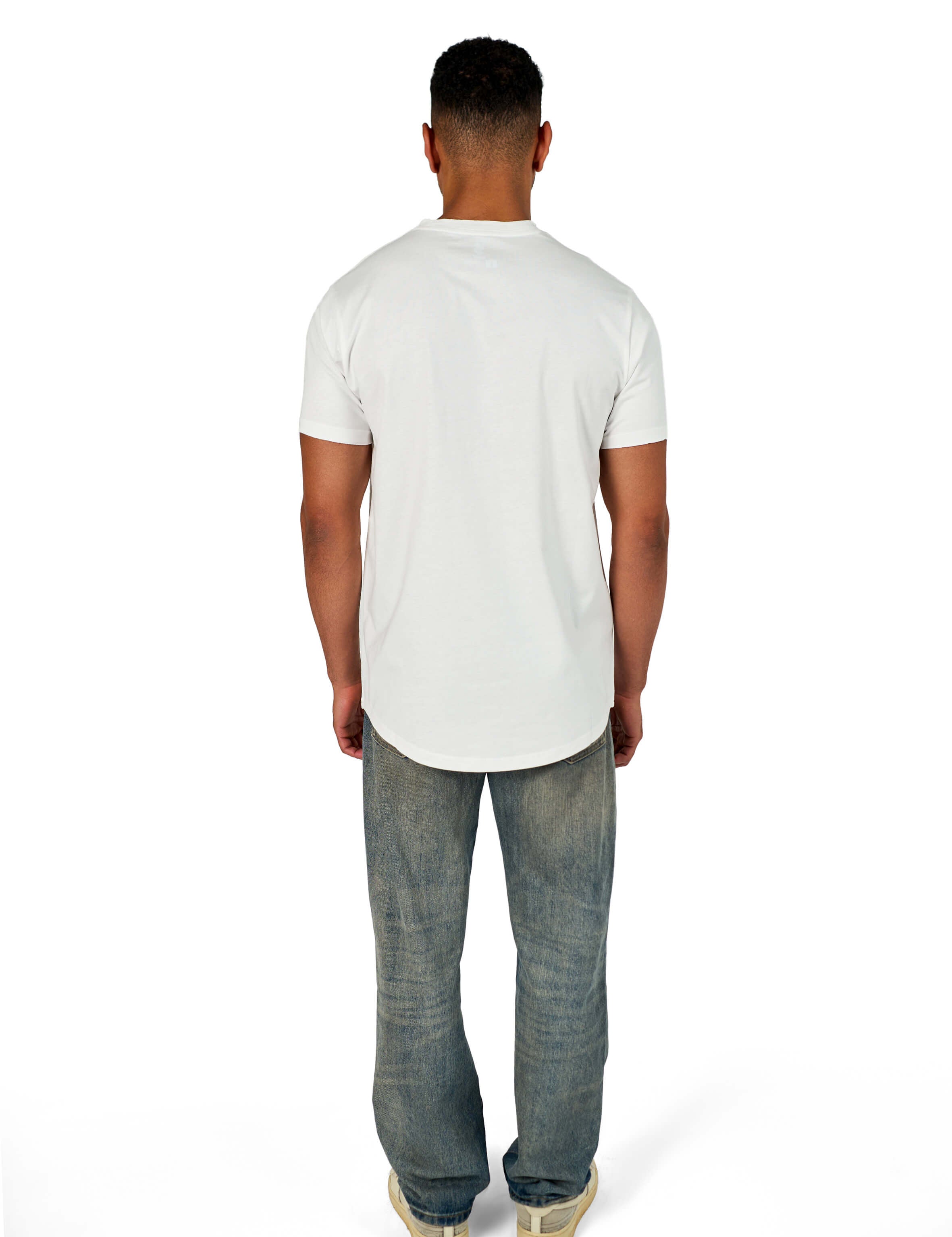 A male model wearing a white raw-edged cotton crew neck t-shirt with short sleeves and a rounded hem.