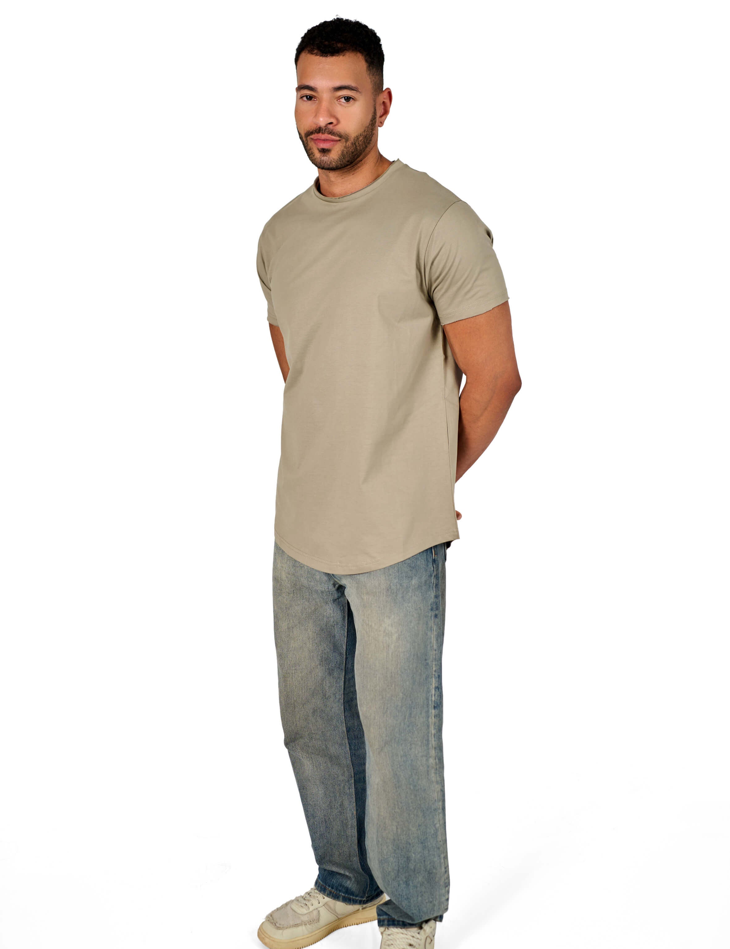 A male model wearing a raw-edged cotton crew neck t-shirt with short sleeves and a rounded hem.
