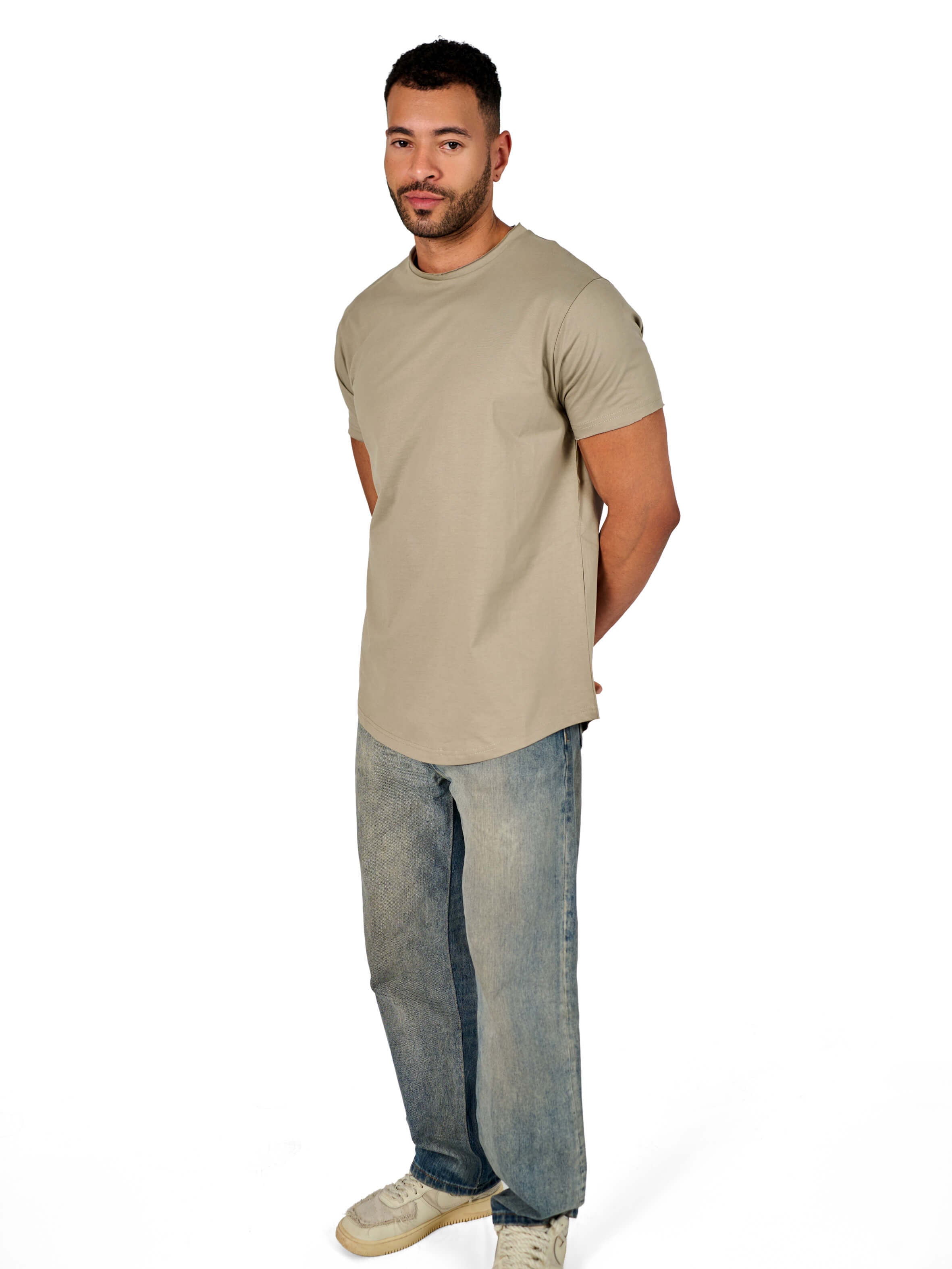 A male model wearing a raw-edged cotton crew neck t-shirt with short sleeves and a rounded hem.