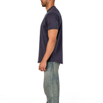 A male model wearing a raw-edged cotton crew neck t-shirt with short sleeves and a rounded hem.