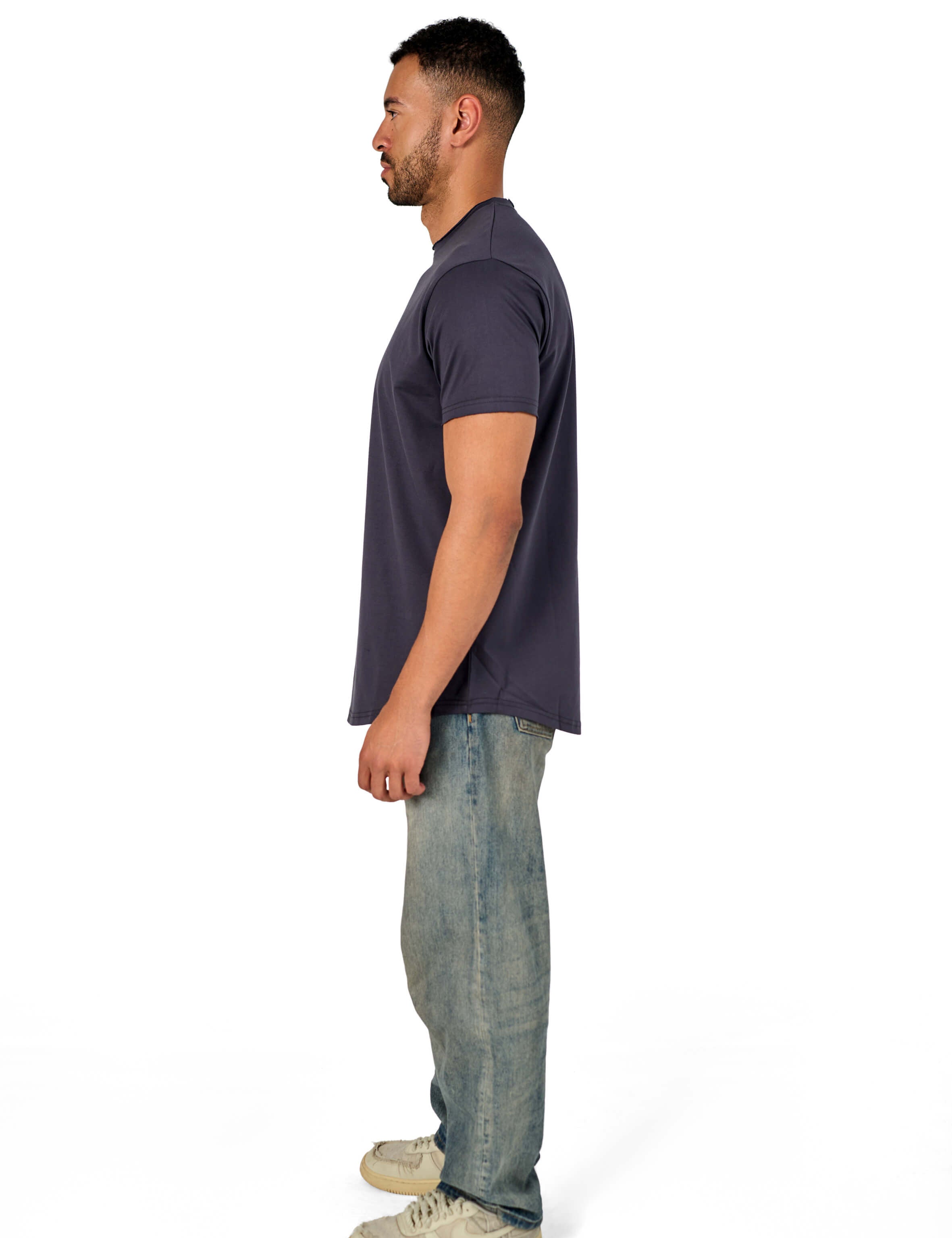 A male model wearing a raw-edged cotton crew neck t-shirt with short sleeves and a rounded hem.