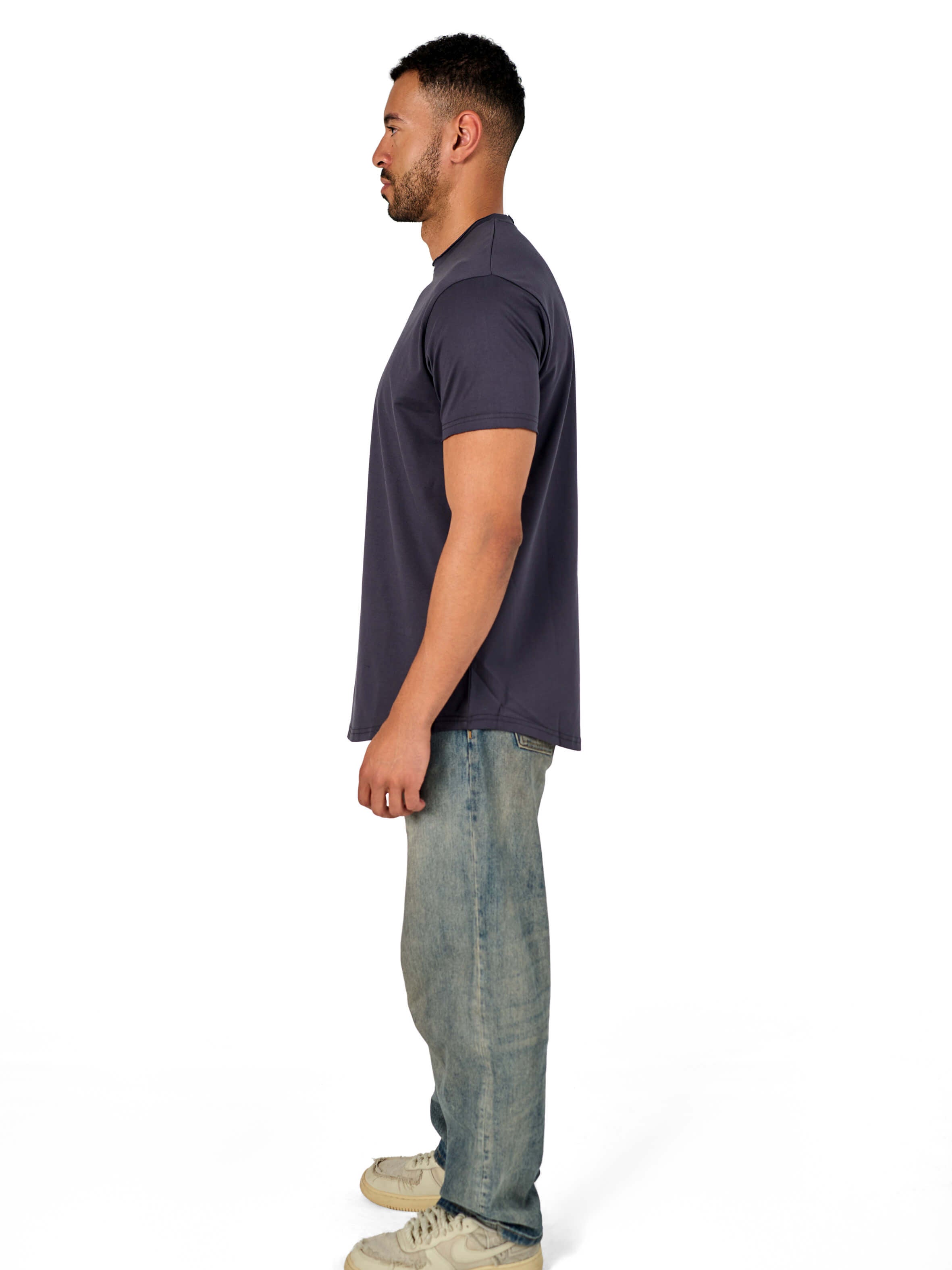 A male model wearing a raw-edged cotton crew neck t-shirt with short sleeves and a rounded hem.
