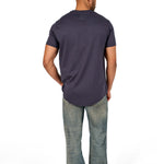 A male model wearing a raw-edged cotton crew neck t-shirt with short sleeves and a rounded hem.