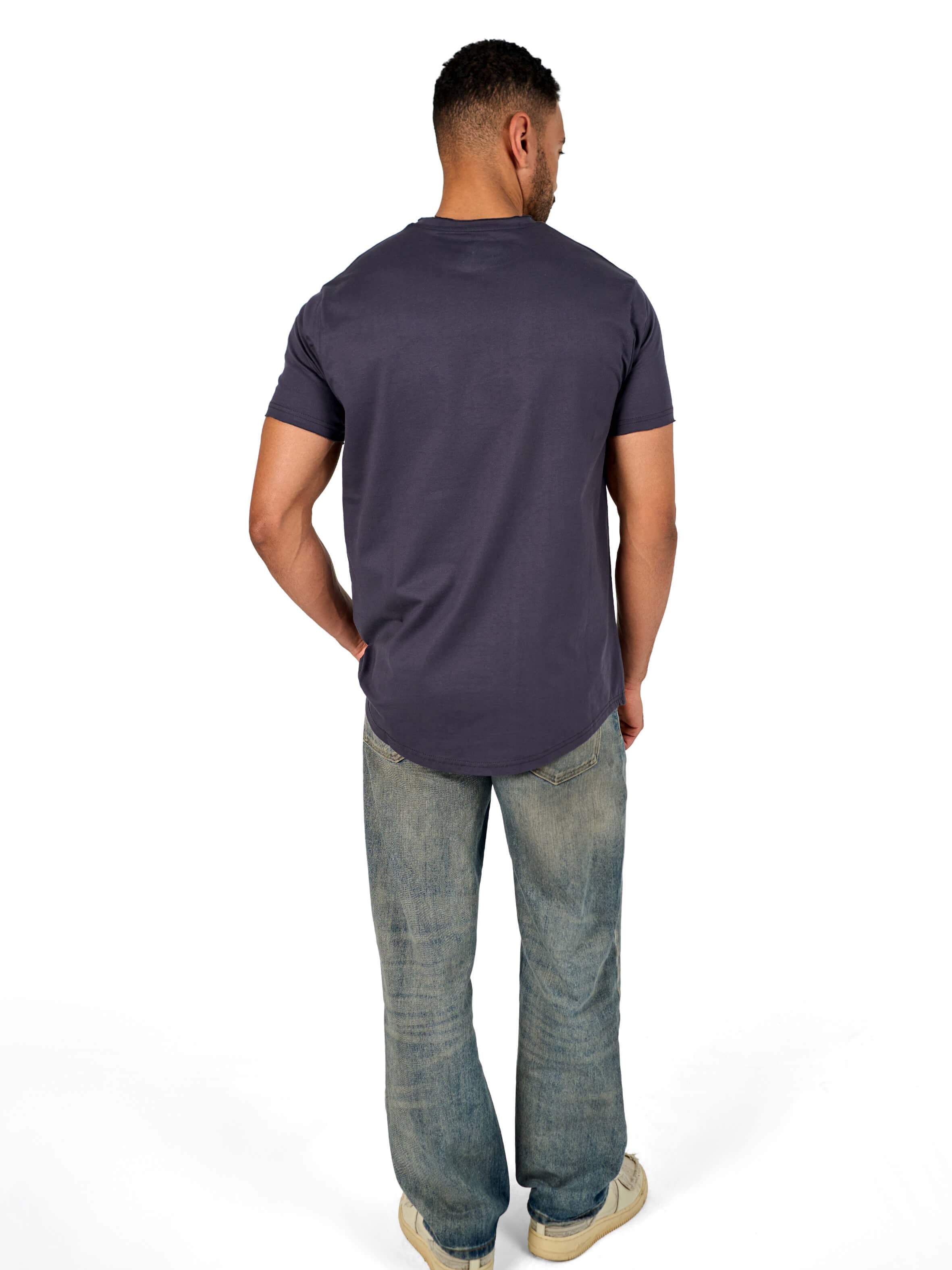 A male model wearing a raw-edged cotton crew neck t-shirt with short sleeves and a rounded hem.