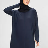 Woman wearing a long-sleeve navy modest loose sports activewear top with a hijab on a white background, branded 'LUXE'.